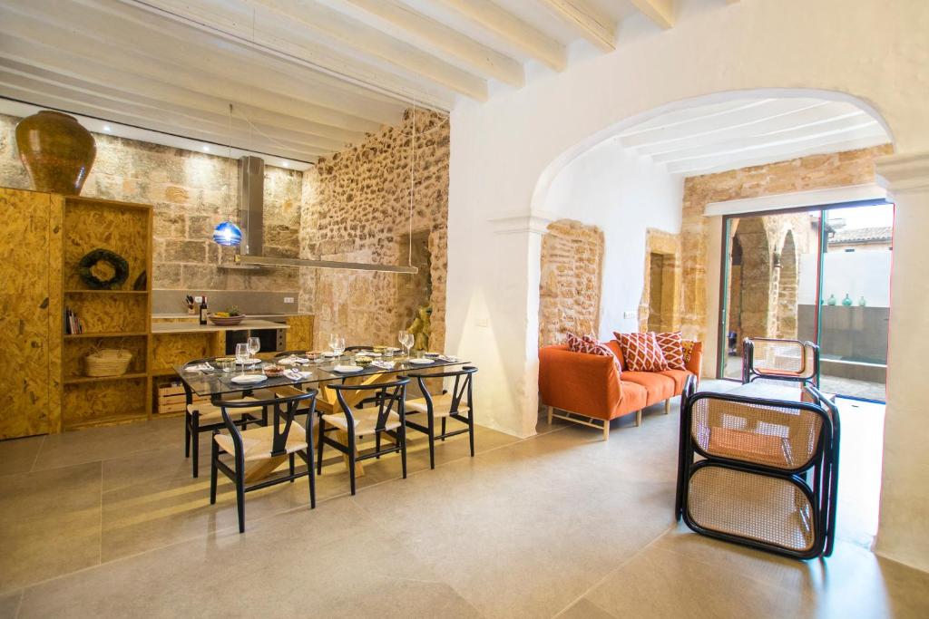アルクーディアにあるVila Roja, design townhouse in Alcúdiaのダイニングルーム(テーブル、椅子、ソファ付)