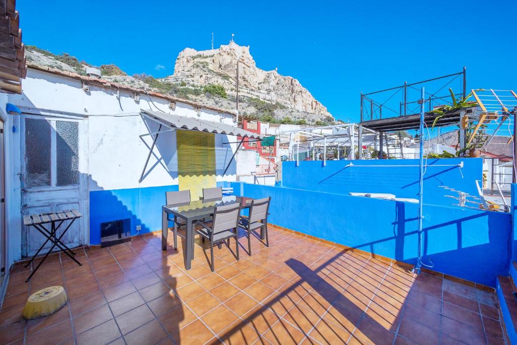 a balcony with a table and chairs on a blue wall at Christine´s Apartment in Alicante