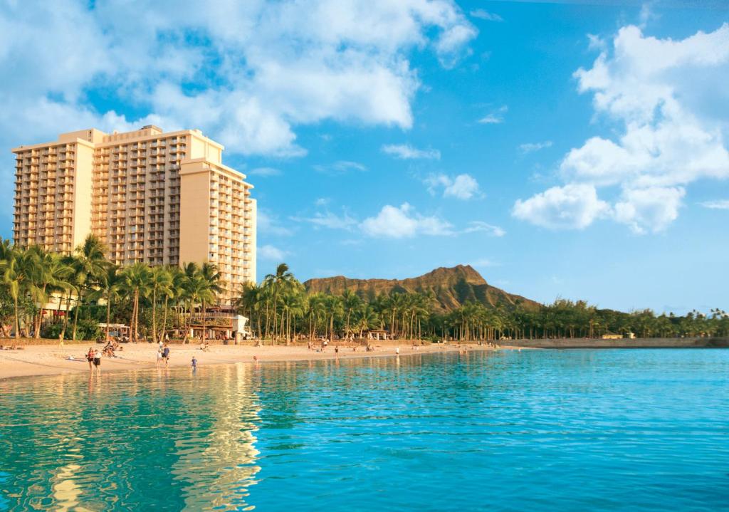 - une vue sur une plage avec des bâtiments et des personnes dans l'établissement The Twin Fin Hotel, à Honolulu