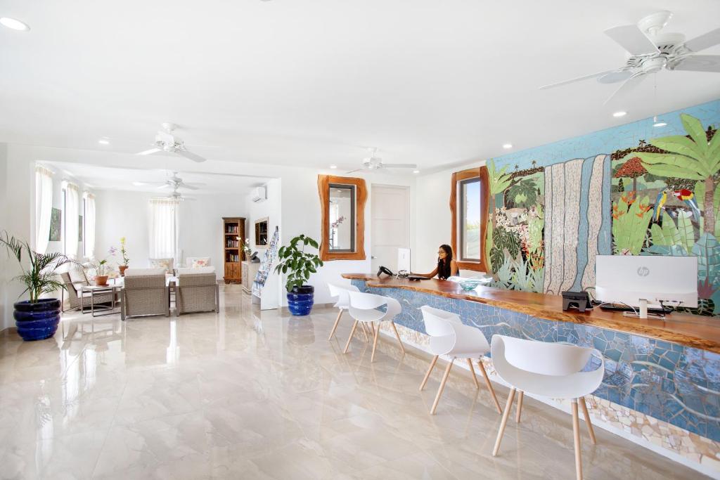 a room with a counter with white chairs and a wall at Beach View Hotel in Saint James
