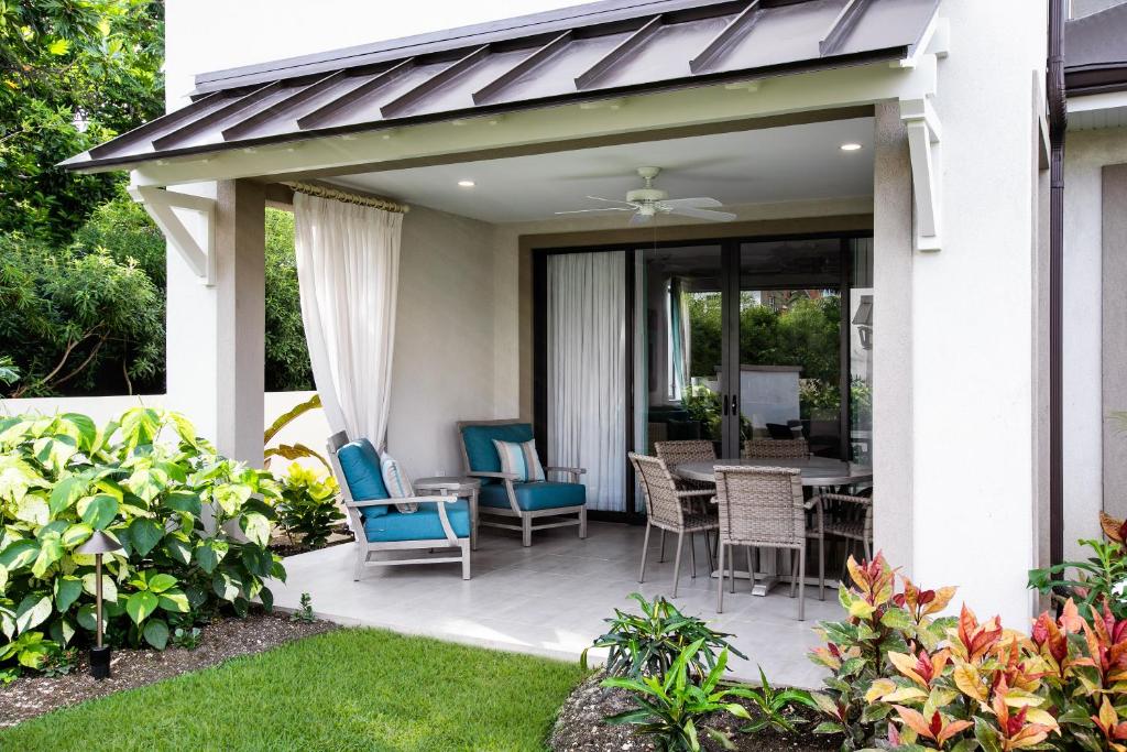 a patio with blue chairs and a table at Beach View Hotel in Saint James