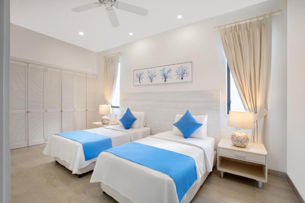 two beds in a room with white and blue at Beach View Hotel in Saint James
