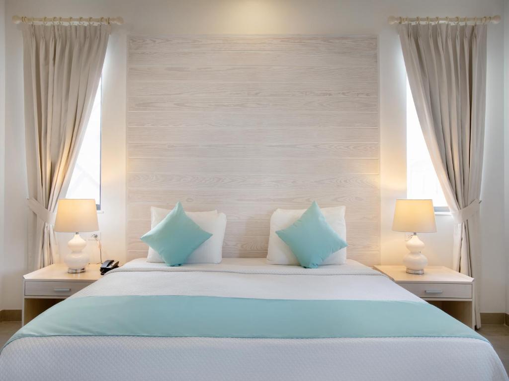 a bedroom with a large bed with blue pillows at Beach View Hotel in Saint James