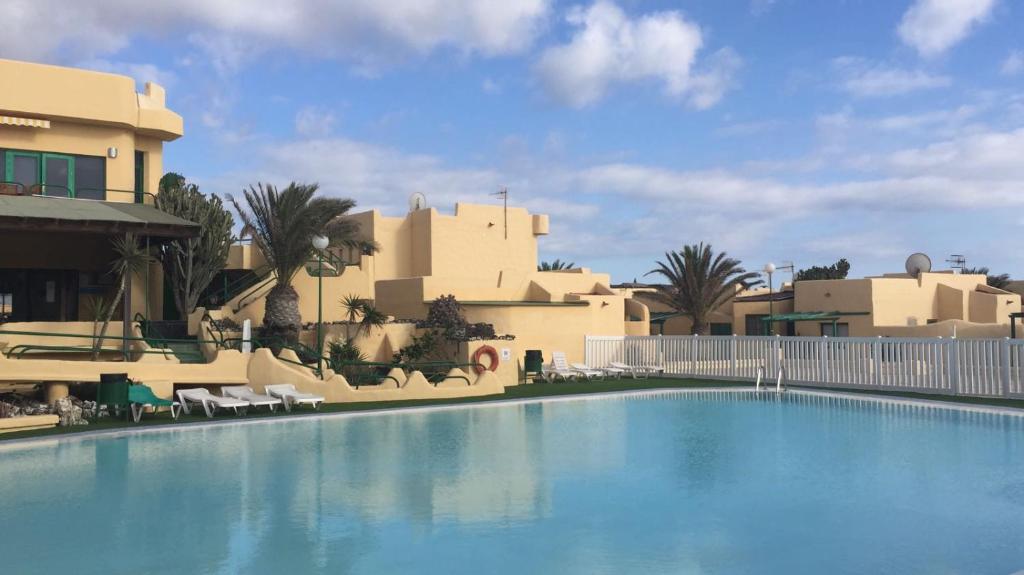 a large swimming pool in front of a building at BEAUTIFUL SMALL APARTAMENT in Costa Calma