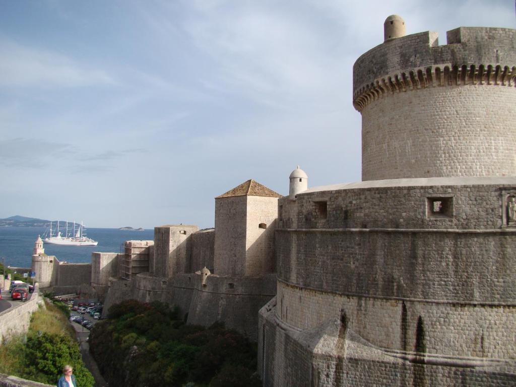 a large castle with a cruise ship in the background at Turtle Apartments in Dubrovnik