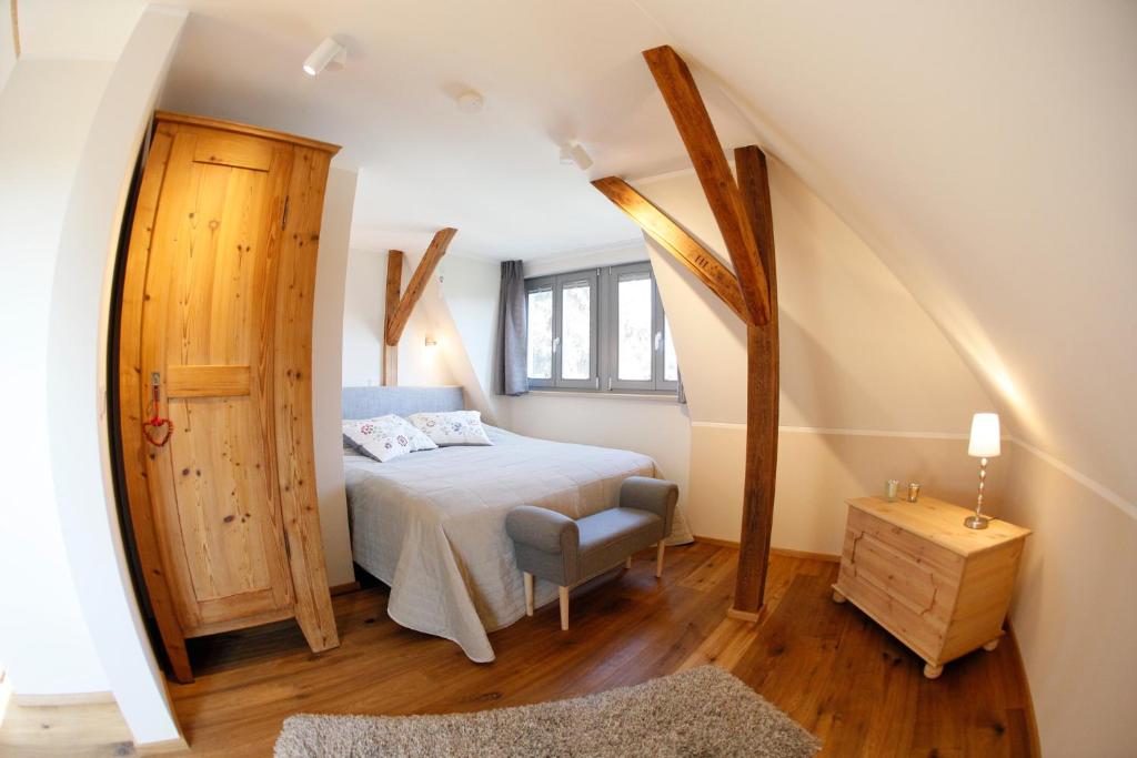 a bedroom with a bed and a chair in a attic at Lieblingswohnung im Elbtal in Coswig