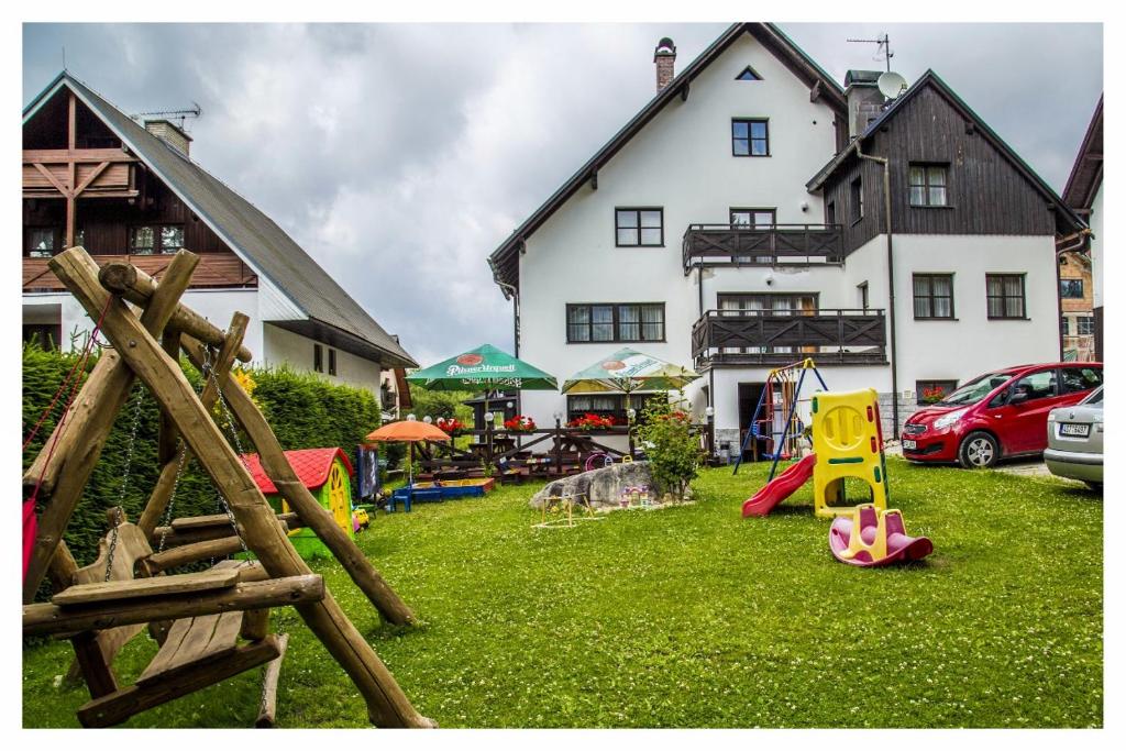 a yard with playground equipment in front of a house at U Bernardýna in Harrachov