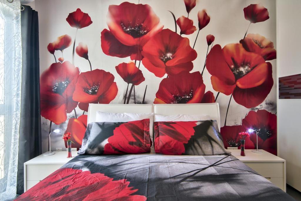 a bedroom with a bed with red flowers on the wall at 189 Chezli Court in Birżebbuġa
