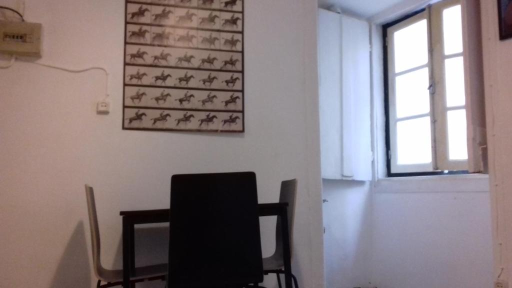 リスボンにあるCity Center | Chiado Typical Small flatの椅子と壁画付きの部屋
