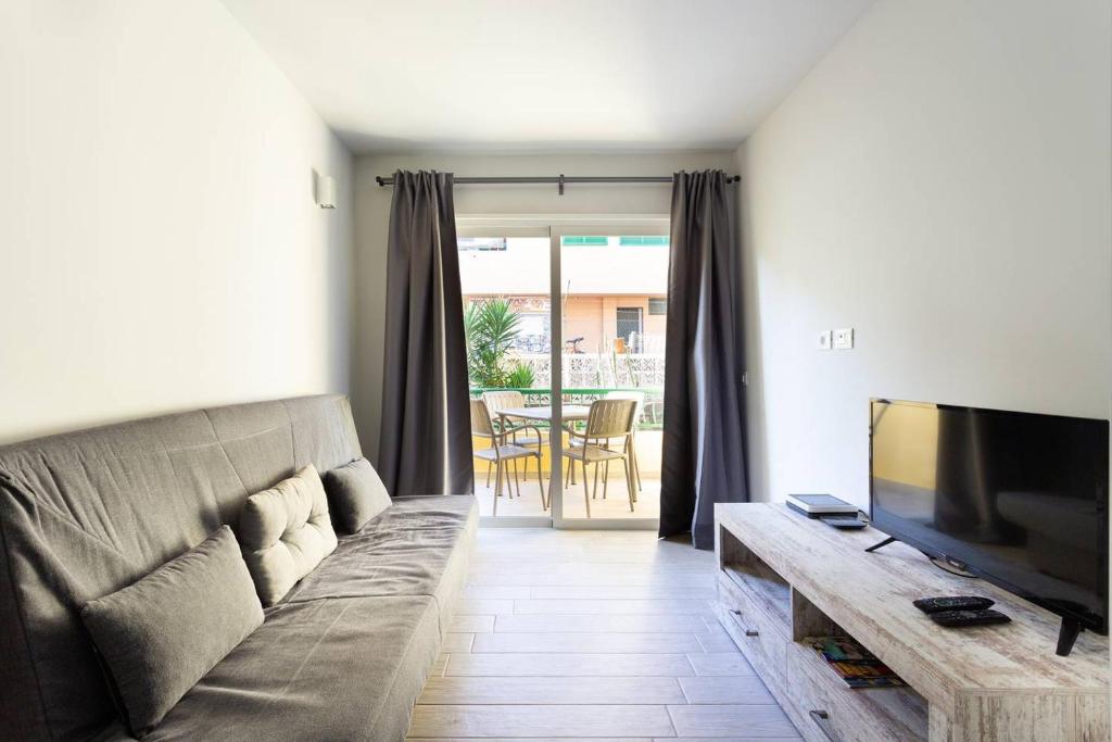 a living room with a couch and a television at Torres del Sol in Arona