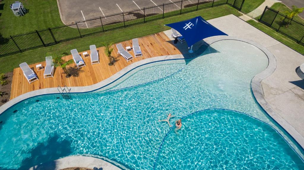 a swimming pool with a blue and white surfboard on top of it at Hotel Forster in Forster