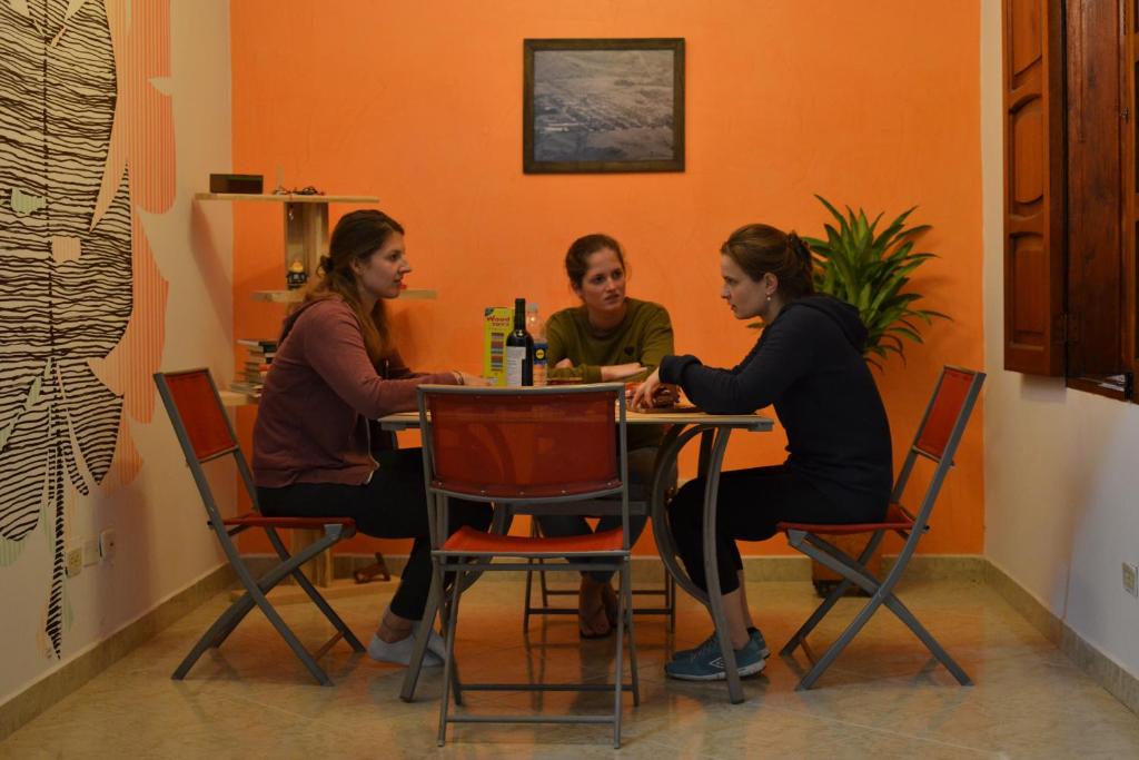 drie vrouwen aan een tafel in een restaurant bij Hostal Naty Luna in Jardin