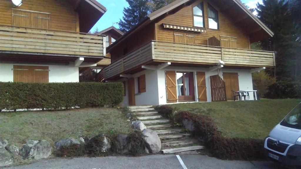 une maison avec une voiture garée devant elle dans l'établissement village vosgien, à Gérardmer