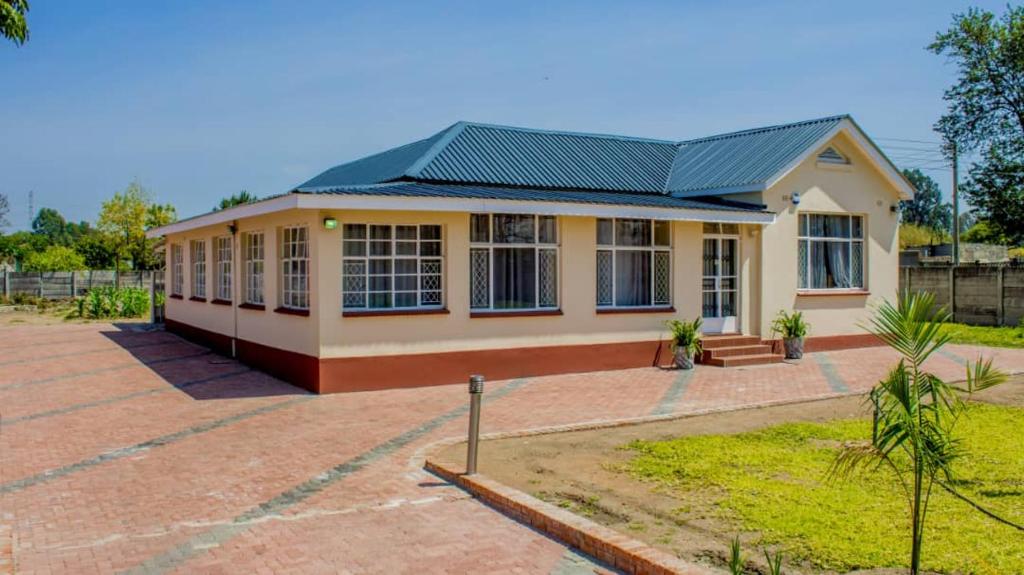 ein kleines Haus mit grünem Dach in der Unterkunft Lynm Residence in Harare