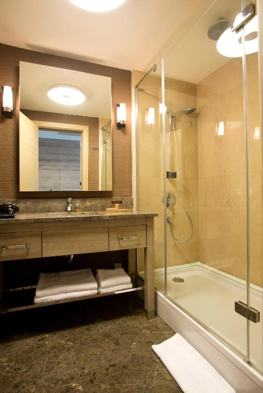a bathroom with a shower and a sink and a tub at Nidya Hotel Galataport in Istanbul