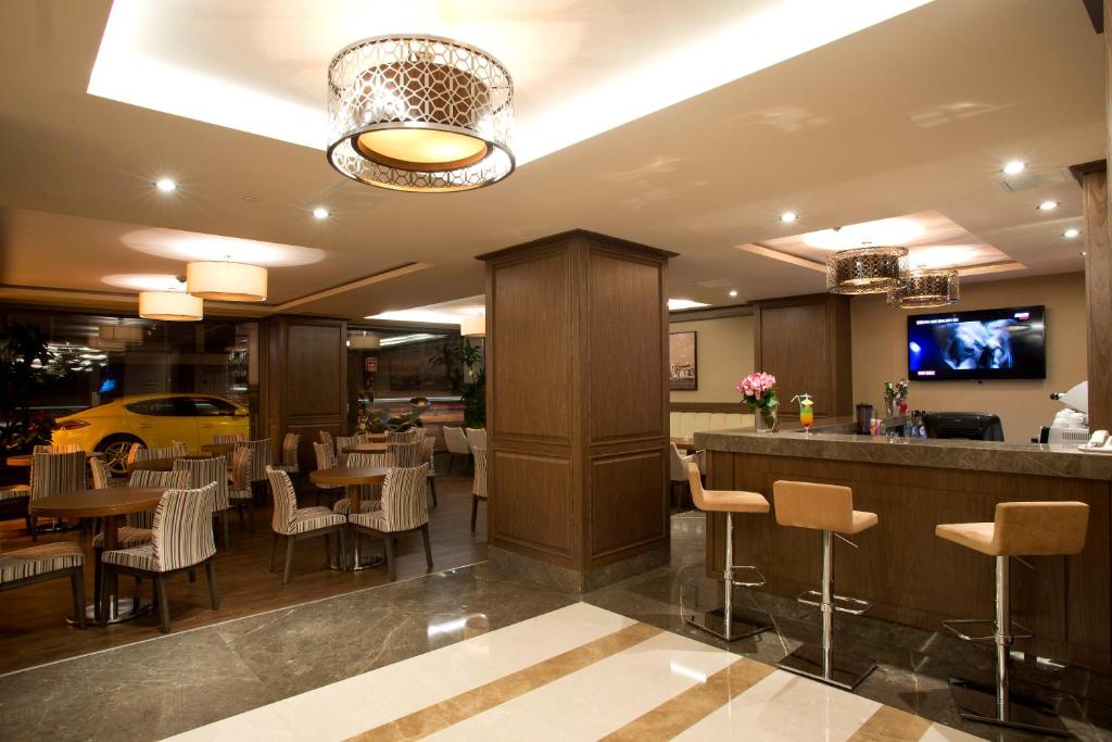a restaurant with a bar and tables and chairs at Nidya Hotel Galataport in Istanbul