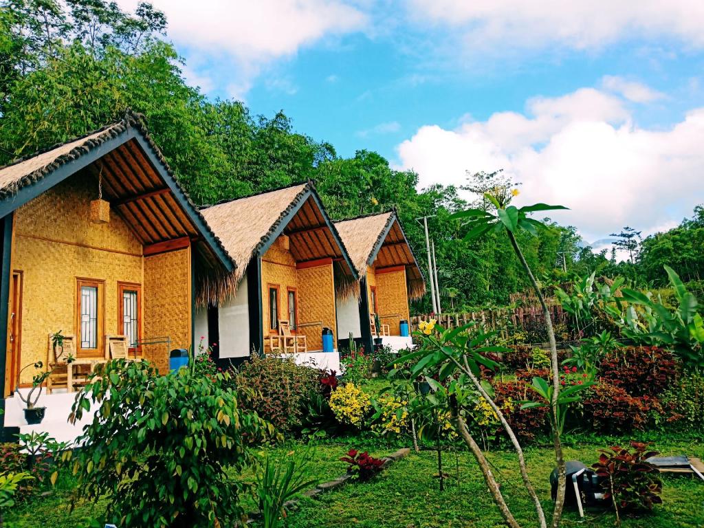 a row of cottages in the middle of a garden at Aryasuta Bungalow in Tetebatu