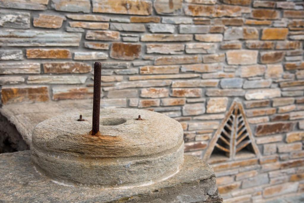 a brick wall with a statue of a bell at Petra Traditional House in Episkopión