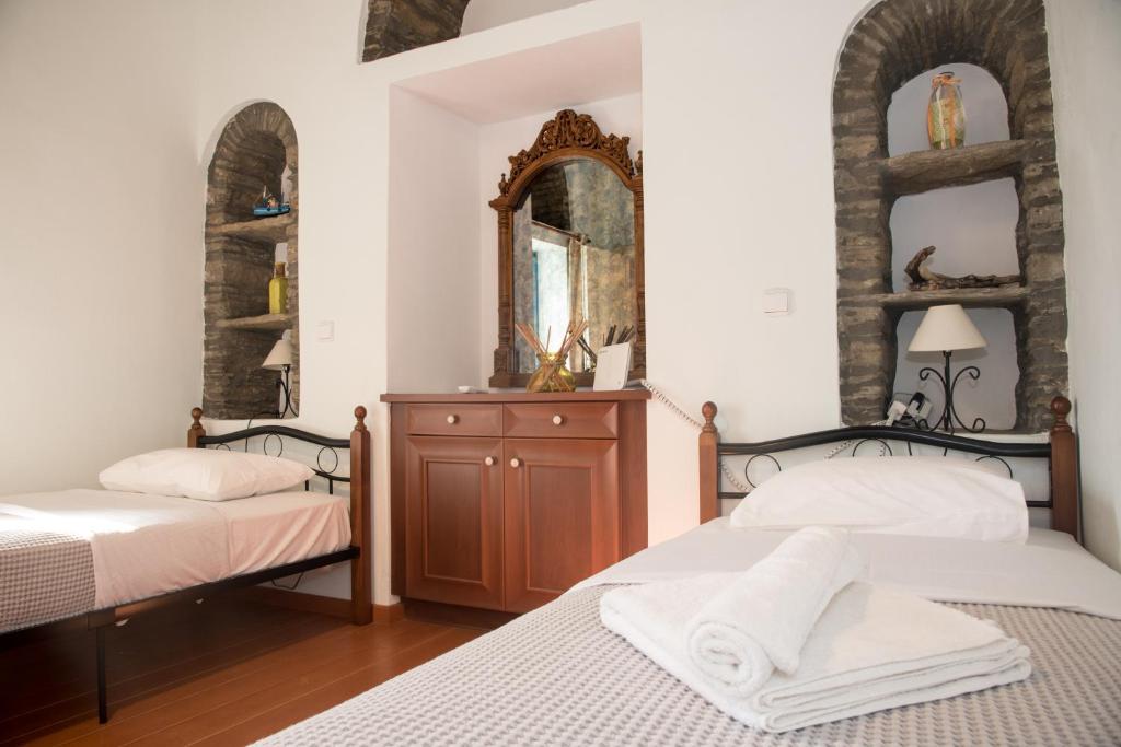 a bedroom with two beds and a mirror at Petra Traditional House in Episkopión