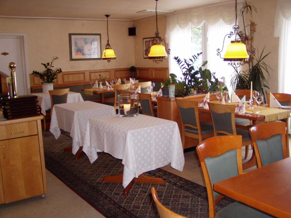 a dining room with tables and chairs and lights at Gasthaus Zum Rothenberg in Lemberg