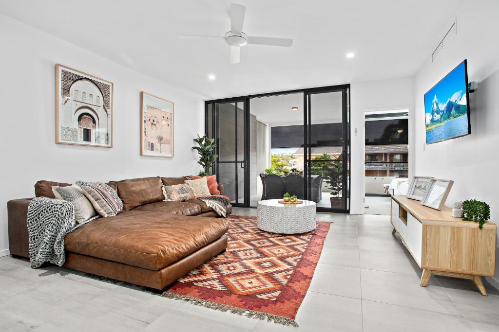 a living room with a brown couch and a table at No 5 Rockpool 69 Ave Sawtell in Sawtell