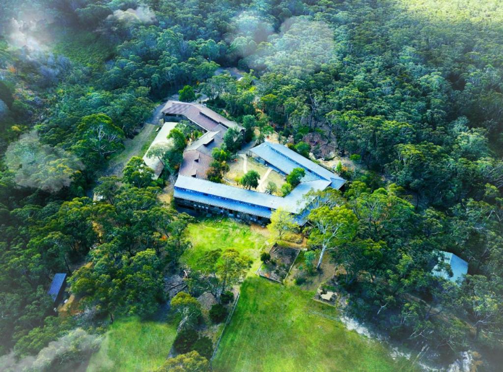 eine Luftansicht eines Hauses inmitten eines Waldes in der Unterkunft Sinofield Edu-Retreat in Leura