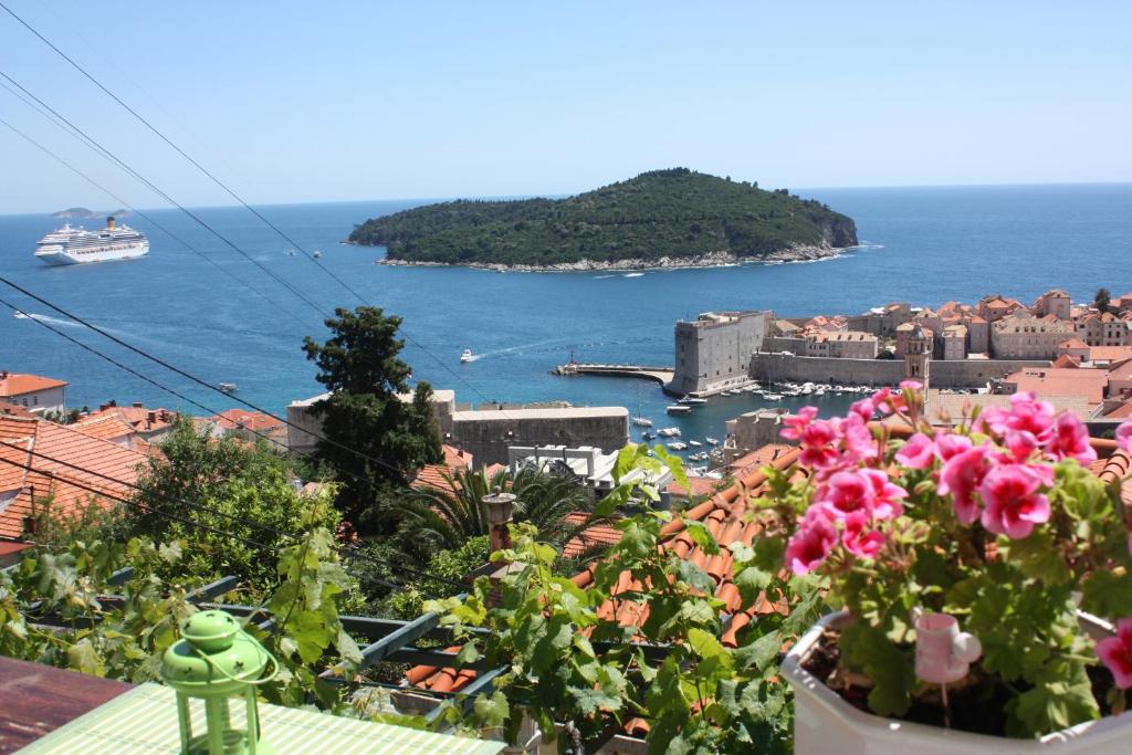 Vistas a una ciudad con flores rosas y al océano en Apartment Arbanasin, en Dubrovnik