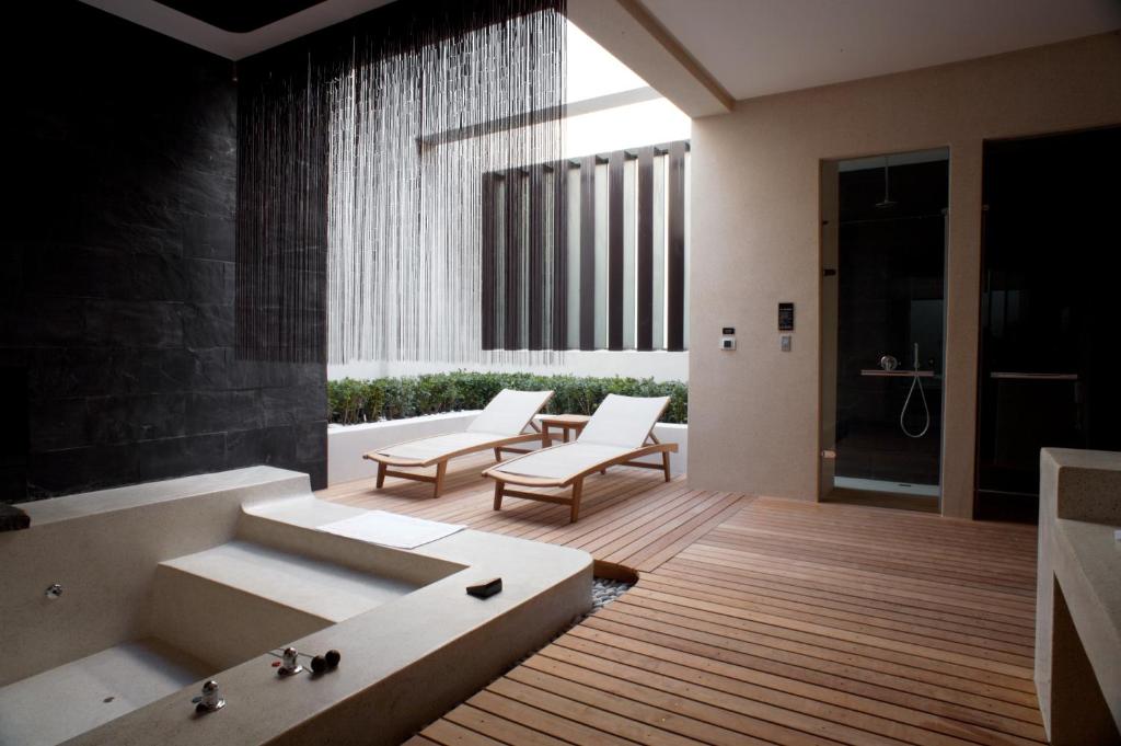 un bagno con 2 sedie e una vasca da bagno di I DO Motel a Taoyuan