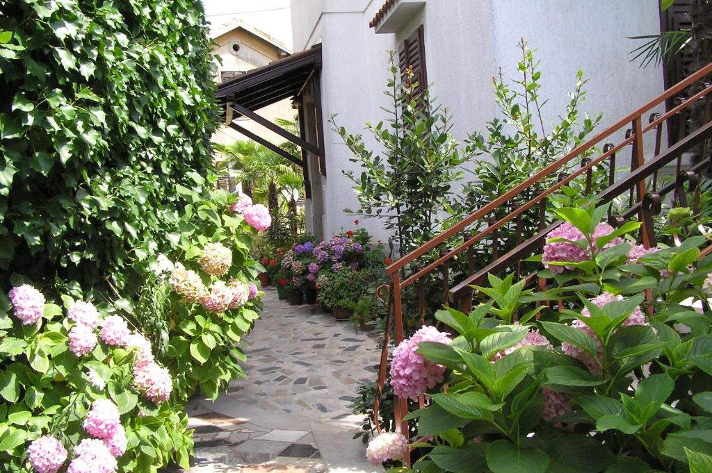 um jardim com flores cor-de-rosa e uma escadaria em Apartments Villa Ida em Opatija