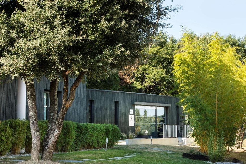 a building with a tree in front of it at Best Western Plus Hotel De La Regate-Erdre in Nantes