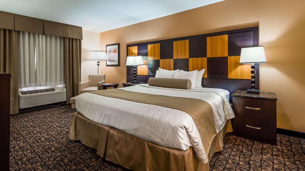 a hotel room with a large bed and a chair at Best Western Plus - Wendover Inn in Wendover