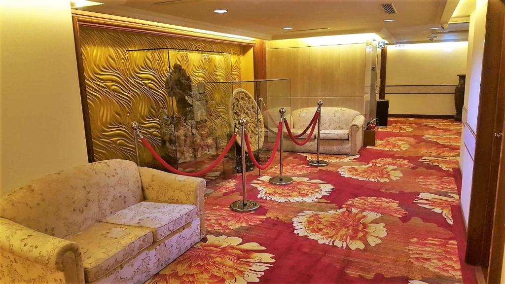a room with a couch and a flower carpet at Chyuan Du Spring Resort in Taipei