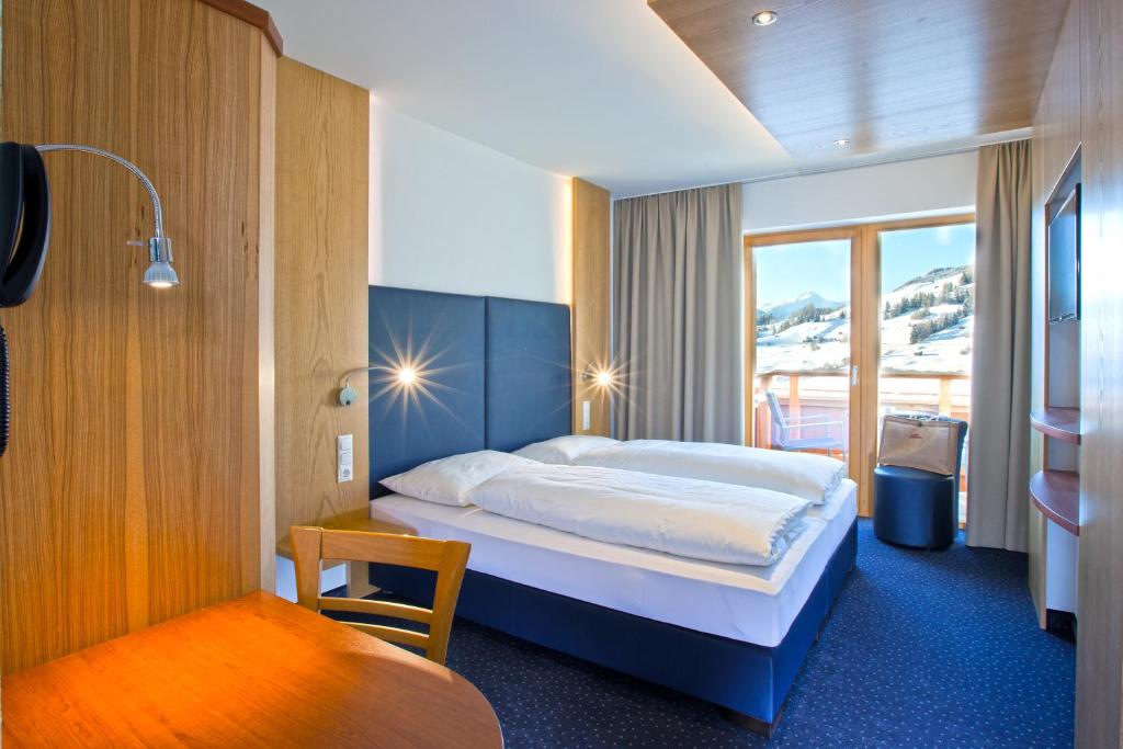 ein Hotelzimmer mit einem Bett und einem Fenster in der Unterkunft Hotel Lukas in Fiss