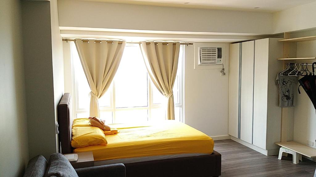 a bedroom with a bed with a large window at Prime Sea View Condo in Davao in Davao City