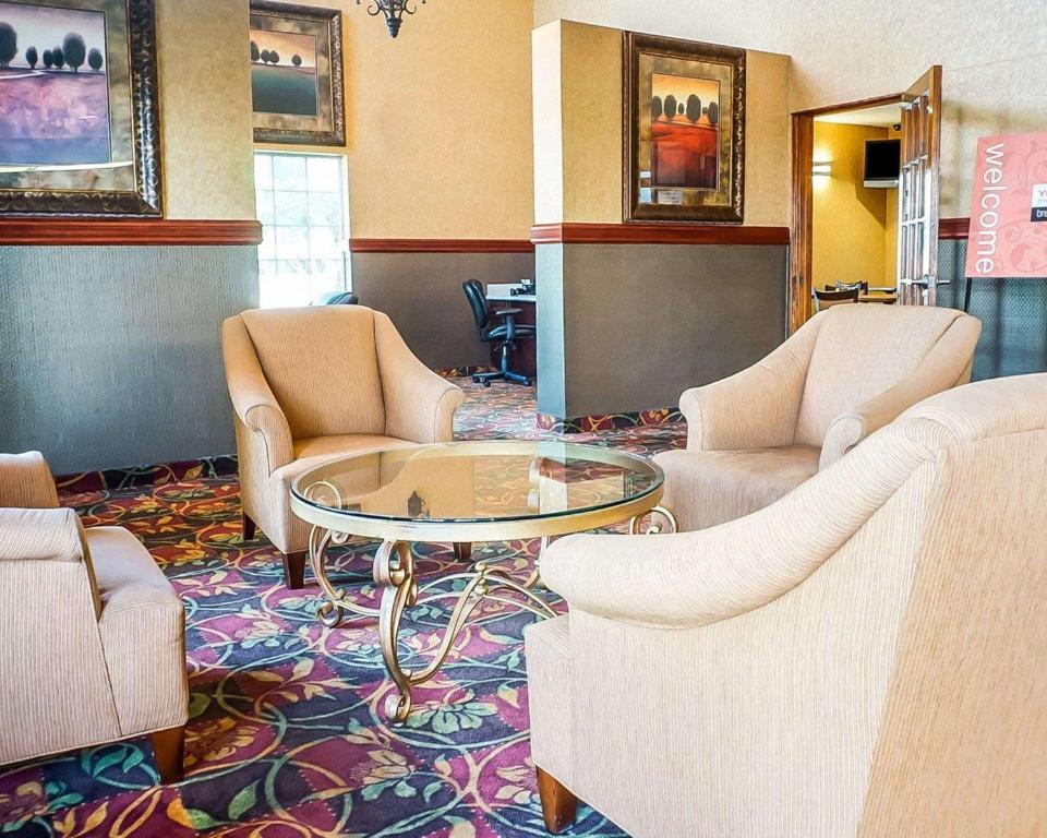 Quality Inn & Suites Roswell في روزويل: غرفة انتظار مع كراسي وطاولة زجاجية