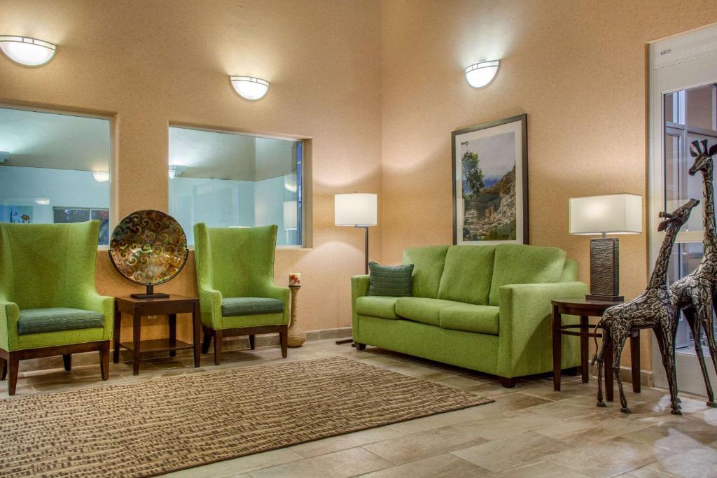 a living room with green chairs and giraffes at Comfort Inn & Suites I-25 near Spaceport America in Truth or Consequences