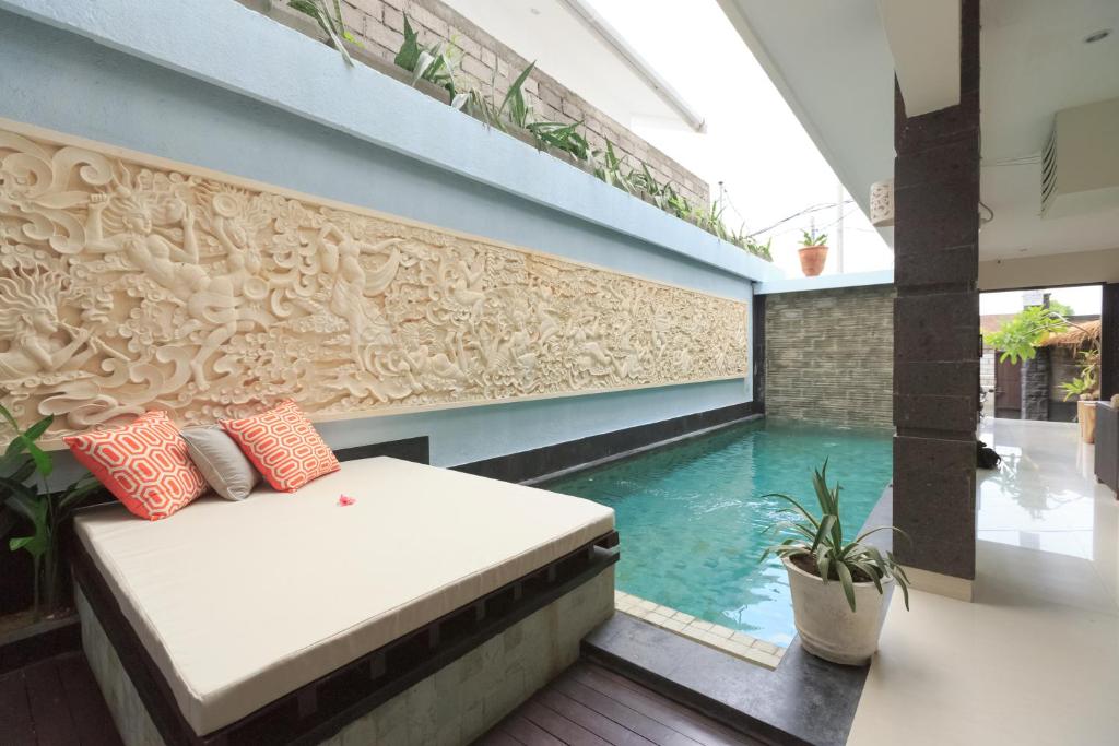 a bedroom with a bed and a swimming pool at Canggu Spirit Guest House in Canggu