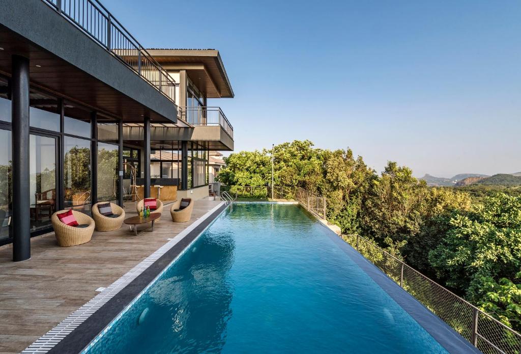 a swimming pool in the middle of a building at SaffronStays Falcon Hill, Lonavala - luxury villa with infinity pool near Lion's Point in Lonavala