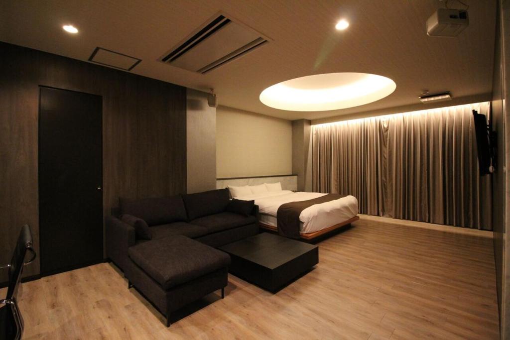 N hotel #NL1 في شيبا: غرفة بسرير واريكة وسرير واريكة