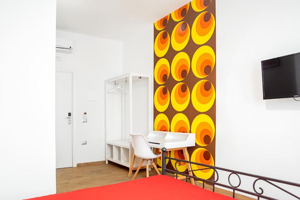 Pokój z biurkiem i telewizorem na ścianie w obiekcie 1970 Rooms w mieście Neapol