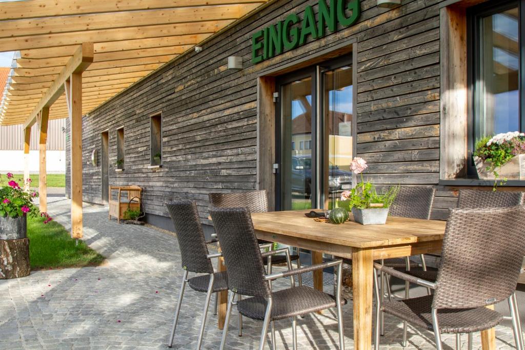 una mesa de madera y sillas frente a un edificio en Gästehaus "In da Wiesn" en Ulrichsberg