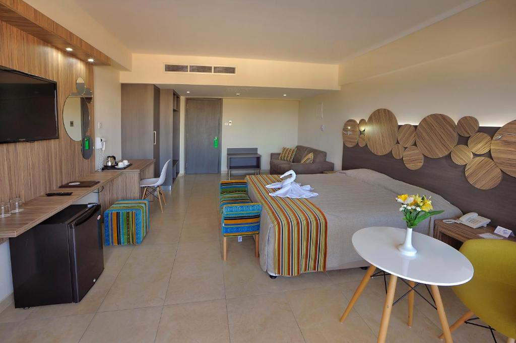 a hotel room with a bed and a kitchen at Nelia Beach Hotel & Spa in Ayia Napa