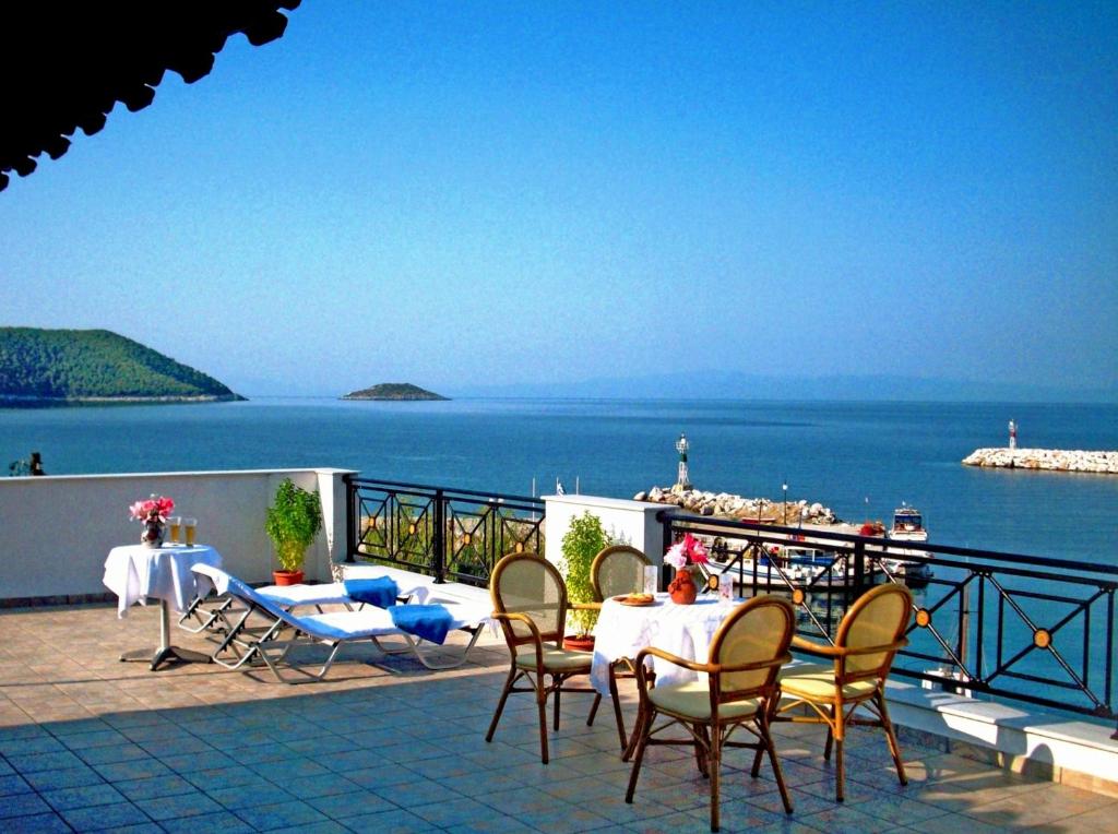 eine Terrasse mit Tischen und Stühlen und Blick auf das Wasser in der Unterkunft Anna Maria - Vanessa Apartments in Neo Klima