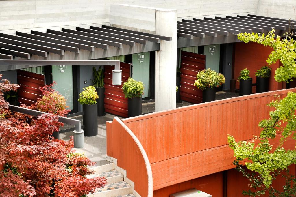 a building with red doors and potted plants at Hotel Holiday La Marca in Villorba