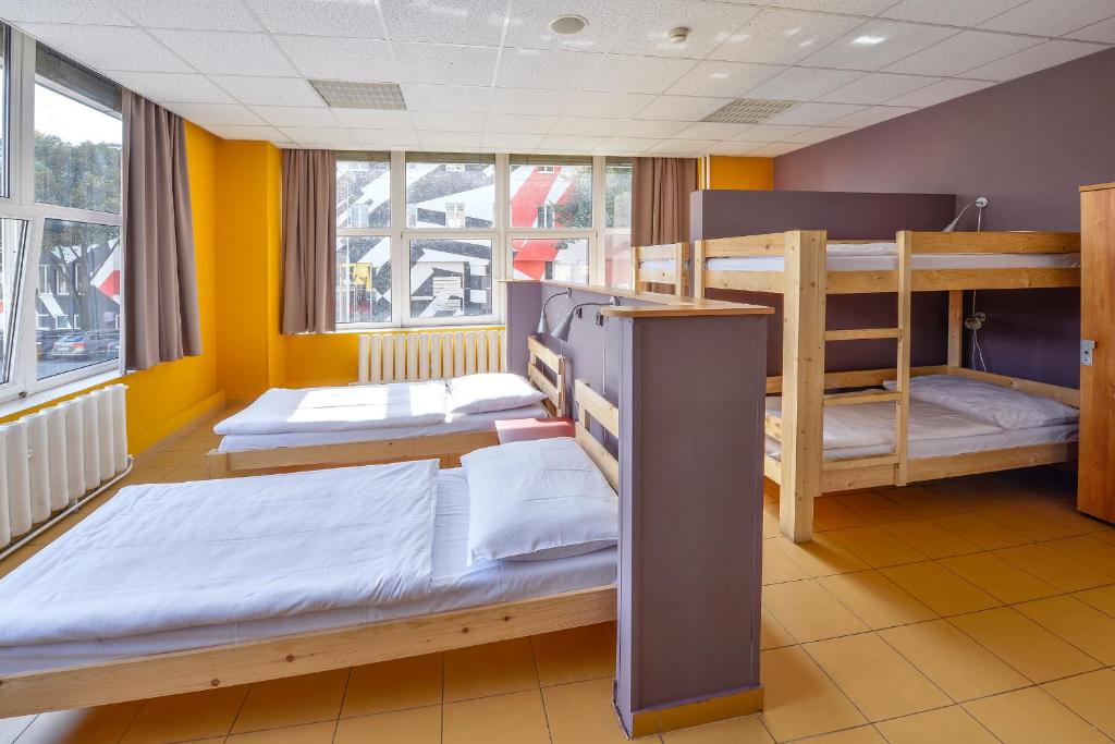 2 łóżka piętrowe w pokoju z żółtymi ścianami w obiekcie Plus Prague w Pradze