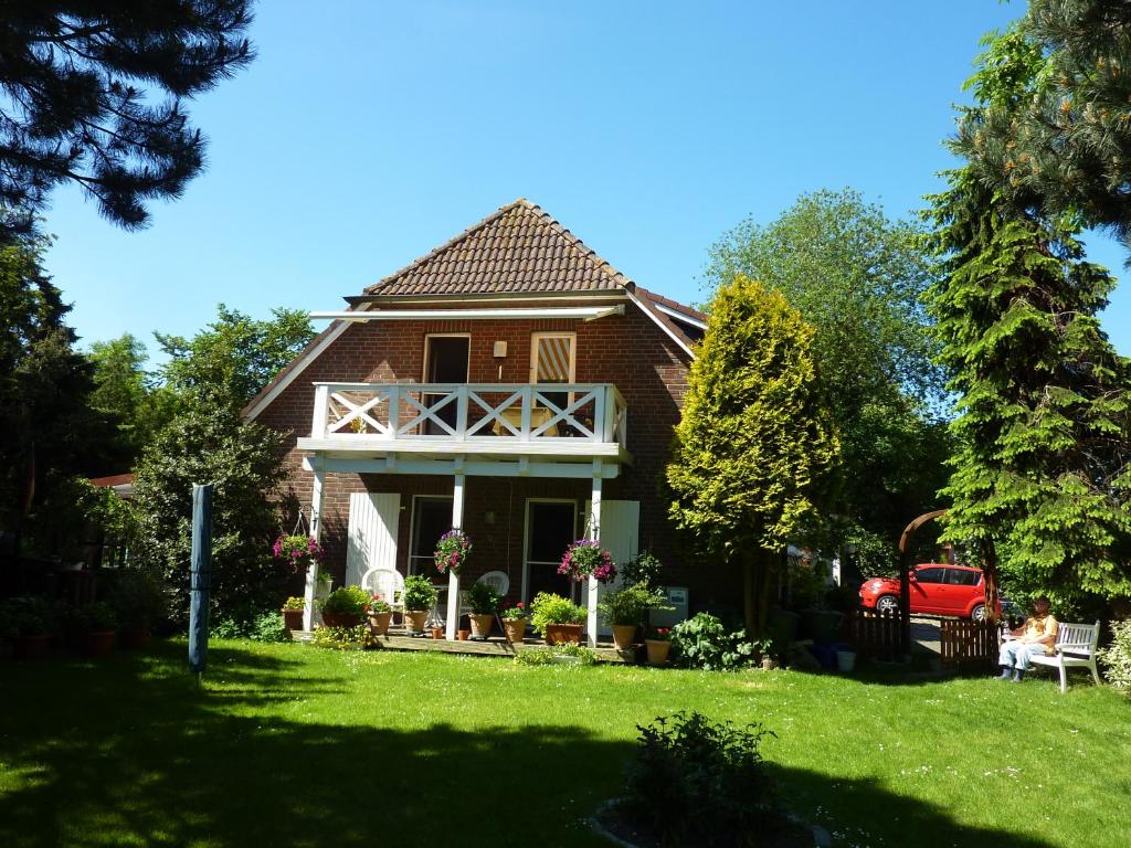 una casa con un coche rojo estacionado en el patio en Haus Backbord, Wohnung Hauptdeck, en Fehmarn