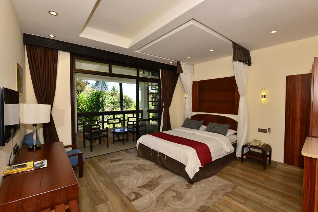 a hotel room with a bed and a balcony at Baobab Holiday Resort in Bamburi