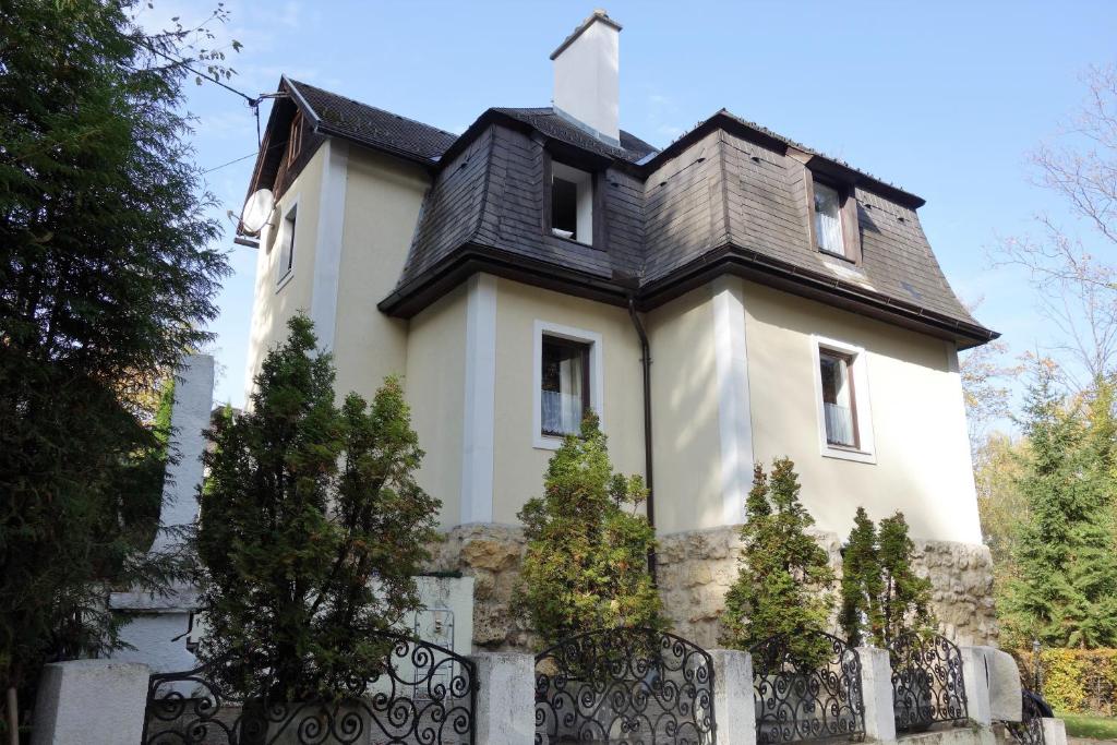 une grande maison blanche avec un toit noir dans l'établissement Villa Agnes, à Semmering