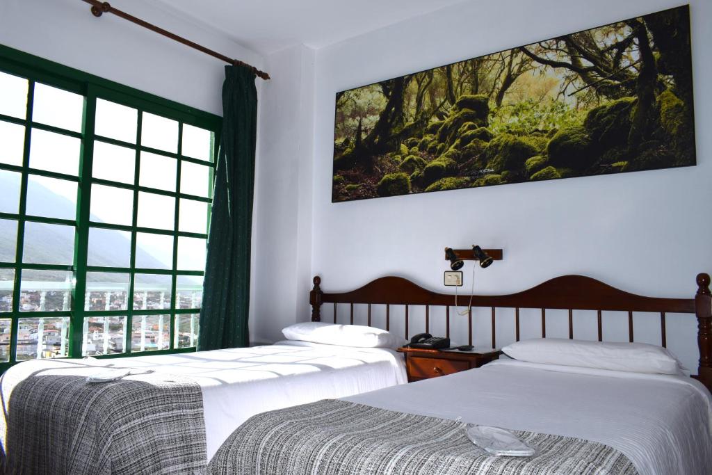 a bedroom with two beds and a large window at Hotel Ida Inés in Frontera