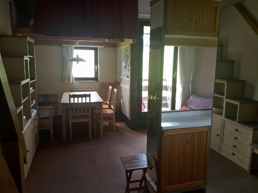 eine Küche und ein Esszimmer mit einem Tisch und einem Schlafzimmer in der Unterkunft Ski Sun 3315 in Manigod